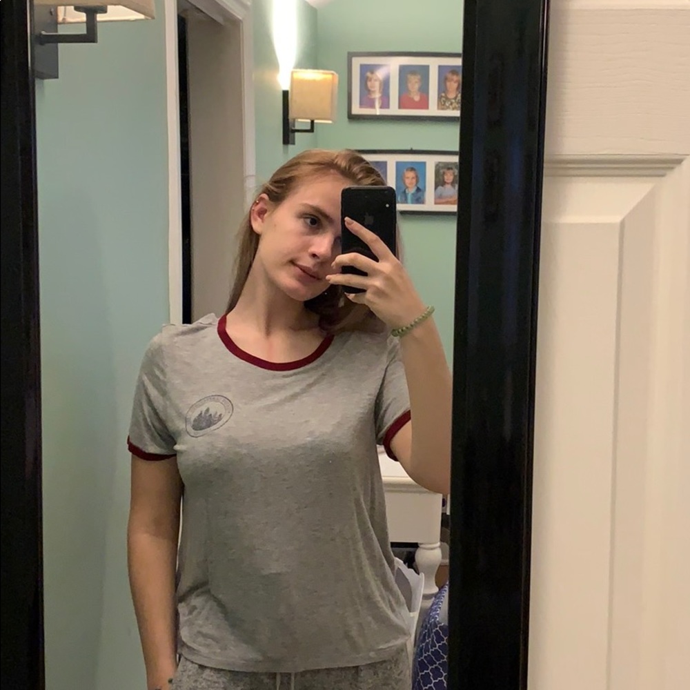 A grey shirt sleeve shirt with red trim.